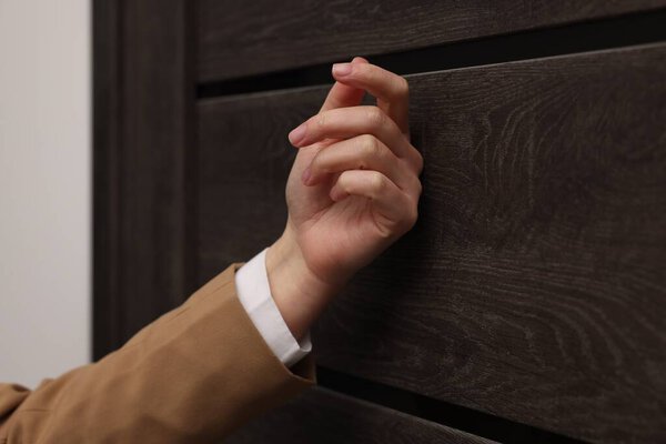 Collector knocking on door indoors, closeup view