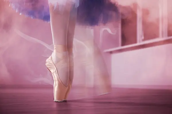 Perfection in ballet. Woman dancing in pointe shoes in studio, closeup. Motion effect with smoke
