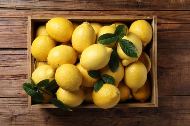 Tahta masada sandıkta taze limonlar, üst manzara.