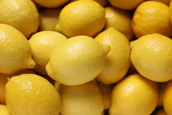 Fresh lemons as background, closeup. Citrus fruit