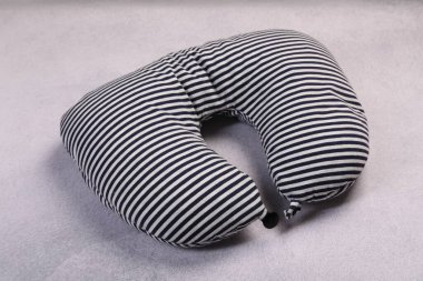 Açık gri masada çizgili seyahat yastığı