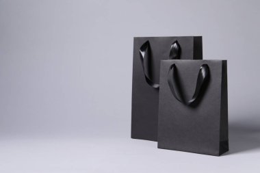 Açık gri arkaplanda siyah kağıt torbalar, metin için boşluk