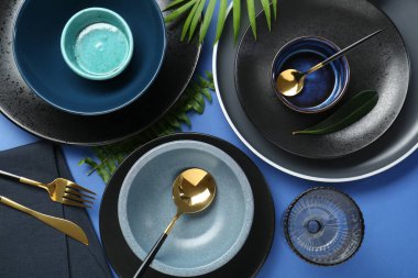 Mavi zemin üzerinde şık seramik plakalar ve çiçek dekoru ile düz konum