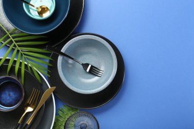 Mavi zemin üzerinde şık seramik plakalar ve çiçek dekoru olan düz konum, metin için boşluk