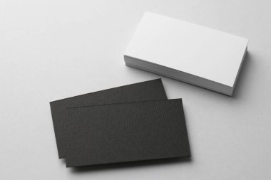 Açık arkaplanda, manzaranın üstünde, boş siyah beyaz kartvizitler. Tasarım için model