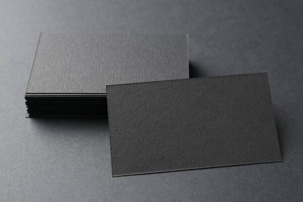 Blank business cards on black background, closeup. Mockup for design