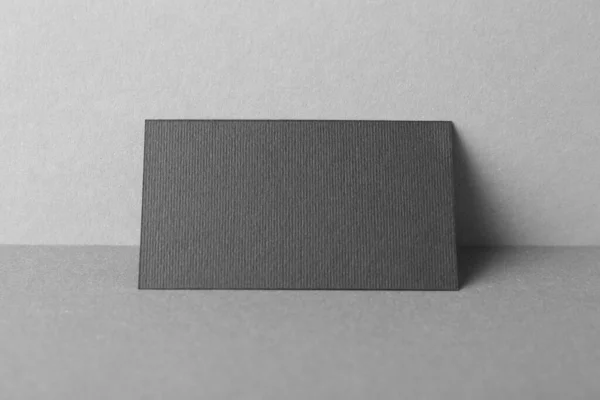 Blank black business card on grey background. Mockup for design