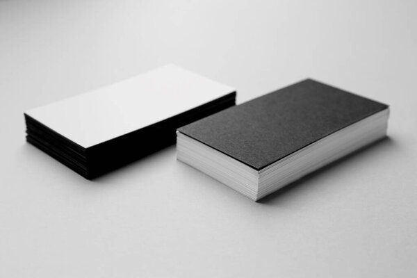 Blank black and white business cards on light background. Mockup for design