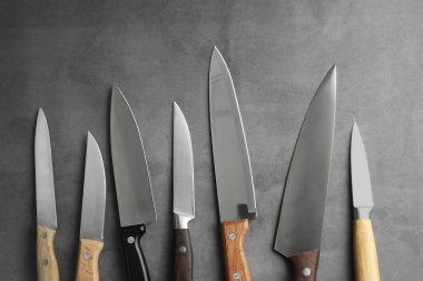 Gri desenli masa üzerinde birçok farklı bıçak, düz yatıyordu.