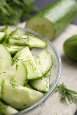 Salatalığı cam kaseyle kes, masaya koy, yakından.