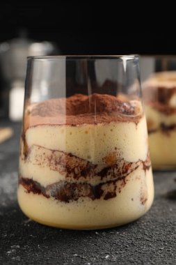 Gri desenli masada cam içinde nefis tiramisu, yakın plan.