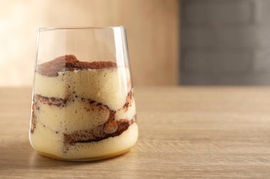 Ahşap masada cam içinde nefis tiramisu, yakın plan. Metin için boşluk