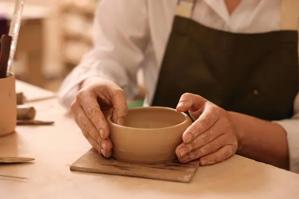 Pottery crafting. Woman sculpting with clay at table, closeup