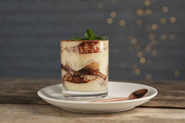 Lezzetli tiramisu ve nane şekeri ahşap masada.