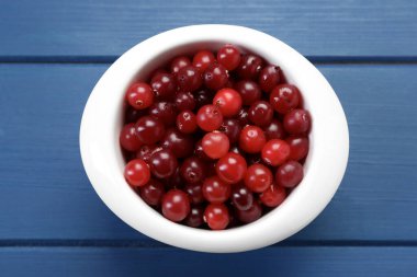 Mavi ahşap masada taze yaban mersini var.