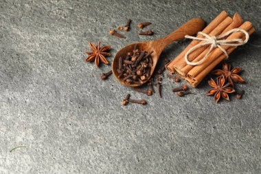 Gri desenli masa üzerinde farklı baharatlarla ahşap kaşık, düz. Metin için boşluk