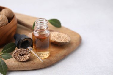 Nutmeg yağı, fındık ve yapraklar ışık masasında, yakın çekim. Metin için boşluk