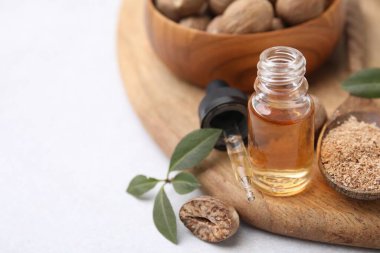 Nutmeg yağı, fındık ve yapraklar ışık masasında, yakın çekim. Metin için boşluk