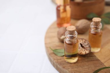 Nutmeg esaslı yağ ve fındıklar beyaz masada. Metin için boşluk