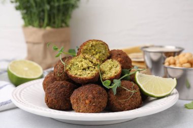 Nefis falafel topları, kireç ve mikro yeşiller ışık masasında.