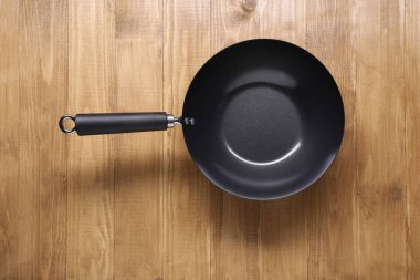 Ahşap masa manzarasında boş demir tava. Çin yemek takımı