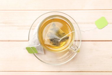 Cam bardakta çay poşeti açık ahşap masa, üst manzara