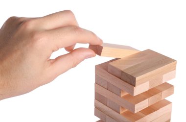 Jenga oynuyorum. Beyaz arka planda tahta blokları olan bir adam kulesi inşa ediyor, yakın plan.