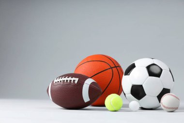 Açık gri arkaplanda birçok farklı spor topu, metin için boşluk