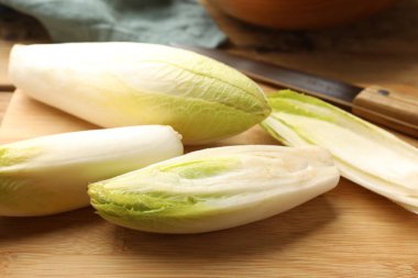 Taze çiğ Belçika hindibaları (hindiba), masaya tahta tahta tahta ve bıçak, yakın plan