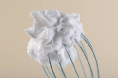 Bej arka planda krem şantili çırpma çırpma, yakın plan.