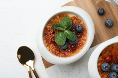 Böğürtlenli ve nane şekerli nefis creme brulee beyaz ahşap masa, üst manzara