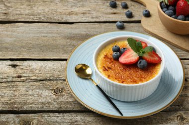 Böğürtlenli nefis creme brulee ve ahşap masada nane şekeri. Metin için boşluk