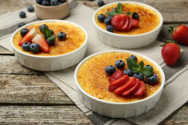 Böğürtlenli ve nane şekerli nefis creme brulee ahşap masada, yakın plan