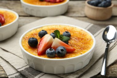Böğürtlenli ve nane şekerli nefis creme brulee ahşap masada, yakın plan