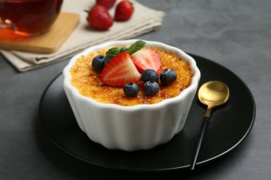 Böğürtlenli nefis creme brulee ve gri masadaki nane şekeri, yakın plan