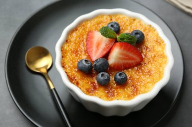 Böğürtlenli nefis creme brulee ve gri masadaki nane şekeri, yakın plan