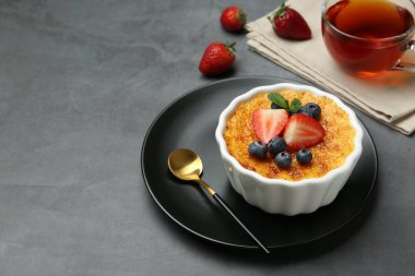 Böğürtlenli nefis creme brulee ve gri masadaki nane şekeri. Metin için boşluk