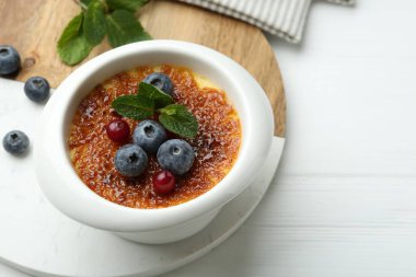 Böğürtlenli nefis creme brulee ve beyaz masada nane şekeri, yakın plan. Metin için boşluk
