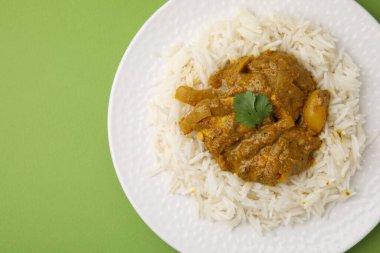 Yeşil arka planda pirinçli leziz tavuk körisi.