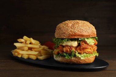 Çıtır tavuk köfteli leziz burger ve ahşap masada patates kızartması.