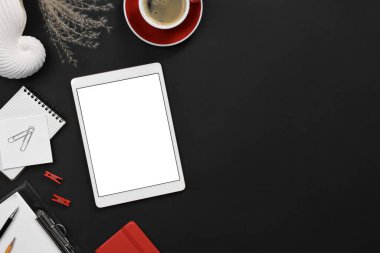 Siyah zemin üzerinde modern tablet bulunan düz kompozisyon. Metin için boşluk