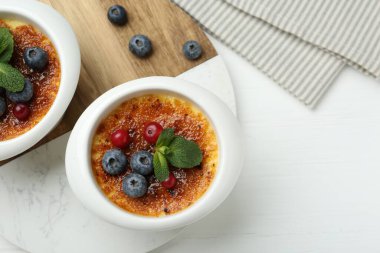 Böğürtlenli ve beyaz ahşap masadaki nane şekerli nefis creme brulee. Metin için boşluk