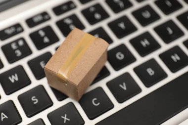 İnternet alışverişi. Dizüstü bilgisayarda küçük bir karton kutu, yakın plan. Metin için boşluk