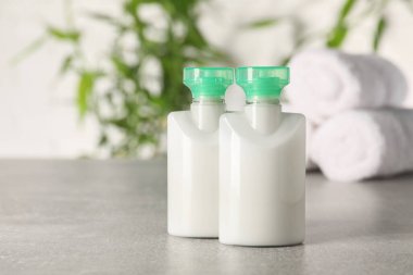 Açık gri masada bulanık arka planda mini kozmetik ürünleri. Metin için boşluk