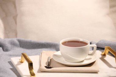 Aromatik çay fincanda, çay tabağında ve kaşıkta yatakta.