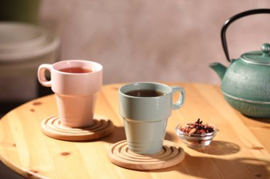 Aromatik çay, kuru çiçek yaprakları ve ahşap masada çaydanlık.