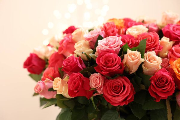 Прекрасный букет разноцветных роз на бежевом фоне, крупным планом