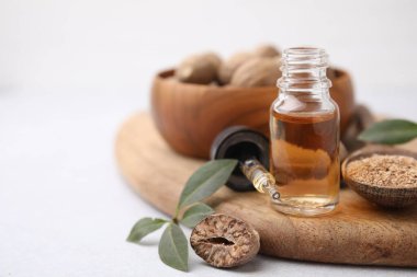 Nutmeg yağı, fındık ve yapraklar ışık masasında, yakın çekim. Metin için boşluk