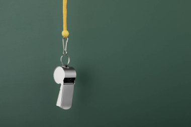 Hakem ekipmanları. Koyu yeşil arkaplanda metal ıslık, metin için yakın plan ve boşluk