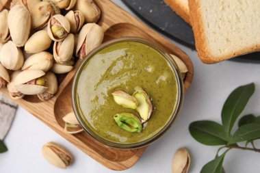 Beyaz masada servis edilen fıstıklı krema ve fındıklar düzdü.